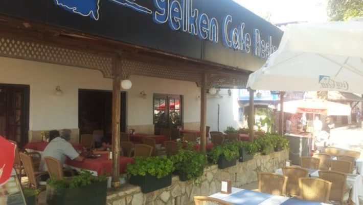 Yelken Restoran Alanya’da deniz manzaralı masada servis edilen deniz ürünleri tabağı; ızgara kalamar, karides, levrek dilimi, yeşillik ve limon dilimleriyle Akdeniz mutfağı sunumu