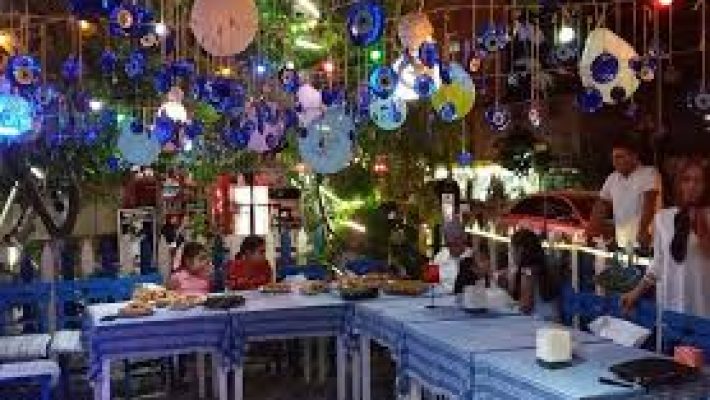 a group of people sitting at a tableNazar Café Alanya’nın deniz manzaralı açık alanında çay ve kahve keyfi yapan misafirler.