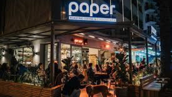 Paper Roasting Coffee & Chocolate Alanya’da latte art ile sunulan kahve ve yanında el yapımı çikolatalar eşliğinde modern, sade masa sunumu