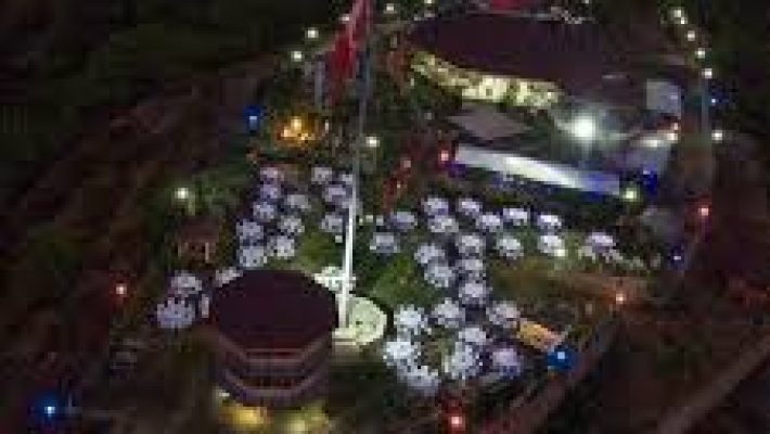 Rüya Tepe Restaurant Alanya’da gün batımı eşliğinde yüksek tepe manzarasına karşı kurulmuş bir masa; masa üzerinde ızgara et, meze tabakları ve içecekler yer almakta.