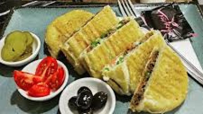 Tostçu Servet Alanya’da çıtır ekmekli, bol kaşarlı tost ve yanında servis edilen patates kızartması ve ayran sunumu