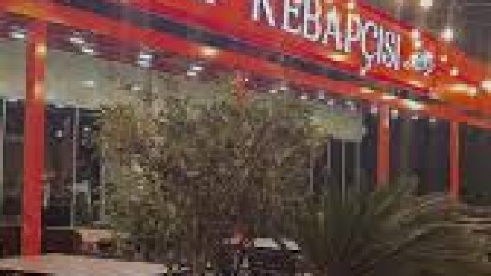 Meşhur Antep Kebapçısı Gazipaşa Alanya'da servis edilen bol közlenmiş sebzelerle süslenmiş Adana kebabı, lavaş ve meze çeşitleriyle birlikte bir masada sunuluyor. Alanya