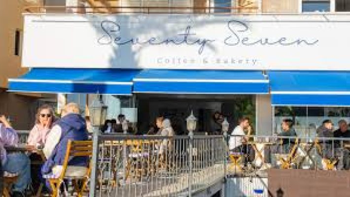 Alanya'da Seventy Seven Coffee & Bakery önünde sergilenen taze kruvasanlar, latte eşliğinde modern bir kahve sunumu