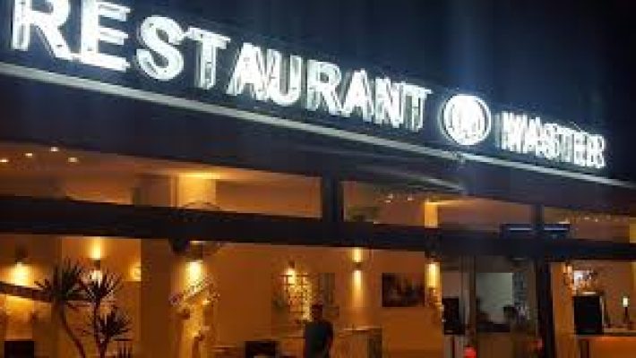 Alanya’da akşam saatlerinde ışıklarla aydınlatılmış Master Bar and Restaurant’ın modern dekorlu açık hava oturma alanı ve şık servis masaları