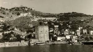 “Tarihi surlar ve Akdeniz’in mavisiyle birleşen Alanya silüeti; antik dönemlerden kalma izlerle modern şehir.”