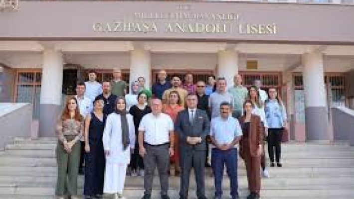 Gazipaşa Anadolu Lisesi binası ve bahçesi, öğrenciler okul girişinde topluluk etkinliği yaparken görülüyor.