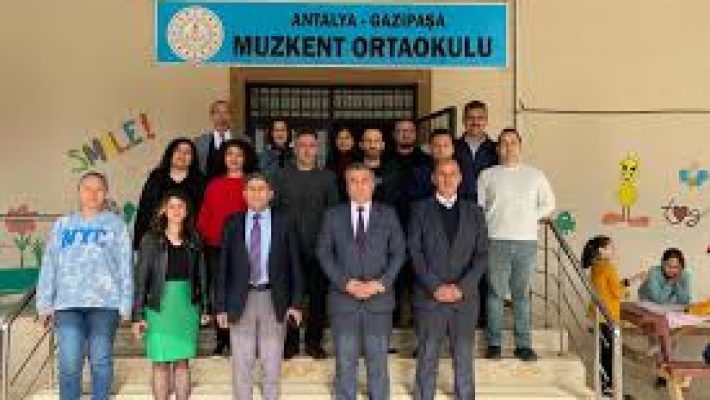 Muzkent Ortaokulu binası ve okul bahçesinde öğrenciler.