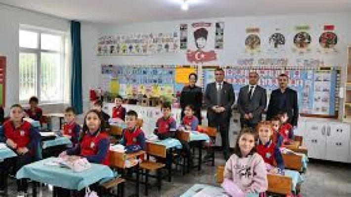 Burhan İlkokulu binası önünde öğrenciler ve öğretmenler okul bahçesinde.