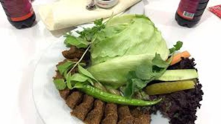 Komagene Güllerpınarı Alanya şubesinde servis edilen bol yeşillikli etsiz çiğköfte dürüm tabağı