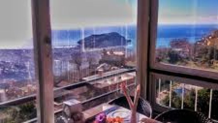 Manzara Restaurant Alanya’da şık bir masa düzeninde, şehir ve deniz panoraması eşliğinde sunulan zengin bir kahvaltı/akşam yemeği sofrası.