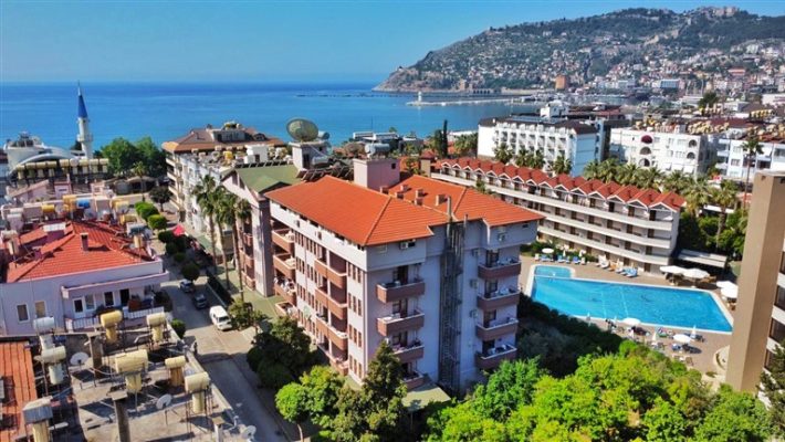 Maren City Apart Hotel’in balkonlu odaları ve açık yüzme havuzu ile Alanya şehir manzarası.