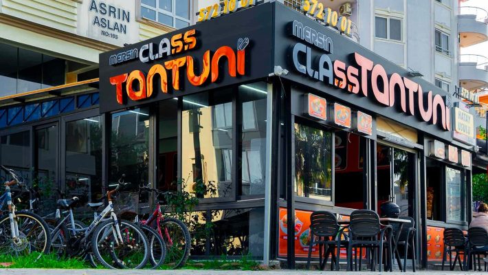 Mersin Class Tantuni’de servis edilen, sıcak sacda hazırlanmış bol etli tantuni dürüm; yanında limon dilimi, acı biber turşusu ve ayran eşliğinde masada görüntülenmiş