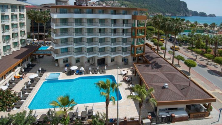 “Riviera Hotel & Spa Alanya’nın palmiyelerle çevrili açık yüzme havuzu, balkonlu odaları ve Kleopatra Plajı’na yakın konumu.”