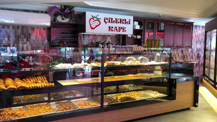 Çilekli kafe Alanya’da renkli bir masa üzerinde çilekli tatlılar ve kahve sunumu