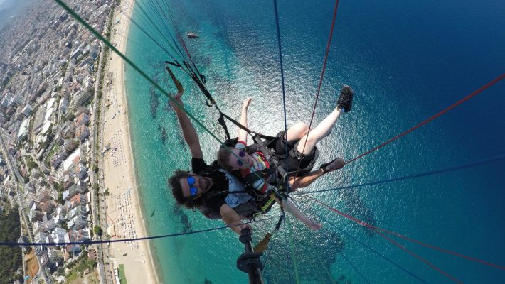 Alanya'da deniz ve dağ manzarası eşliğinde yamaç paraşütü macerası.