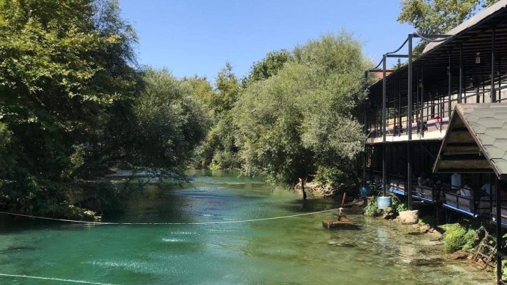Manzara Queen River Piknik alanında doğal dere kenarında kurulu ahşap kamelyalar ve piknik masaları eşliğinde doğayla iç içe huzurlu bir ortam