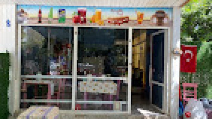 Asmaaltı Ayvalık Tostu’nun servis tabağında yer alan bol malzemeli, çıtır ekmekli Ayvalık tostu; yanında turşu ve patates kızartmasıyla görüntülenmiş