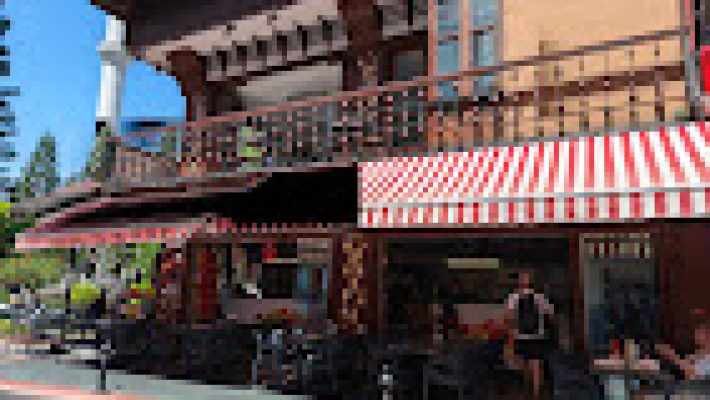 Çağırıcı Büfe'de servis edilen sucuklu-tost ve yanında ayranla birlikte hazırlanmış dolu dolu bir tabak, sokak manzaralı masada görüntülenmiş