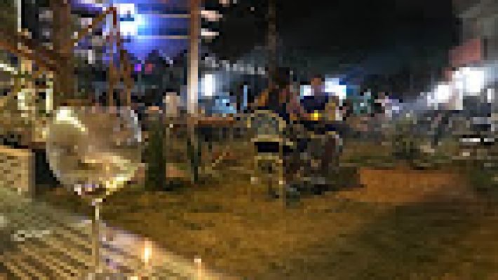 Sacre Cocktails & Restaurant’ta gün batımı eşliğinde servis edilen rengârenk imza kokteyller ve şık tabaklarda sunulan Akdeniz mutfağı lezzetleri, deniz manzaralı bir masada görüntülenmiş