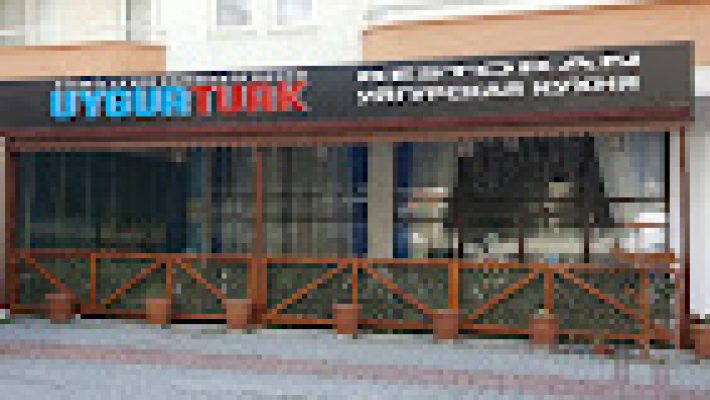 Uygur Türk Restoran’da geleneksel motiflerle dekore edilmiş bir masada servis edilen el yapımı Uygur mantısı ve etli lagman yemeği, sıcak ve otantik ortamda görüntülenmiş