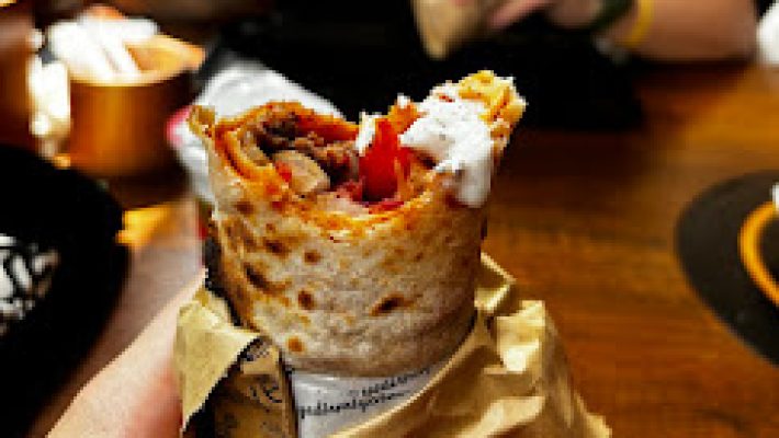 Dürümcü Alanya'da közlenmiş etle hazırlanan leziz bir dürüm, yanında acılı ezme, köz biber ve ayranla birlikte servis edilmiş geleneksel bir Türk sofralarında