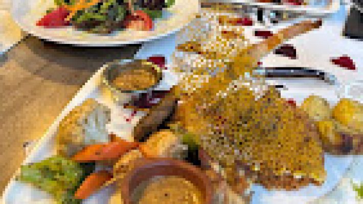 Fish Cafe & Bar Restaurant’ın deniz manzaralı terasında servis edilen ızgara levrek, karides ve zeytinyağlı mezelerle donatılmış zarif bir masa