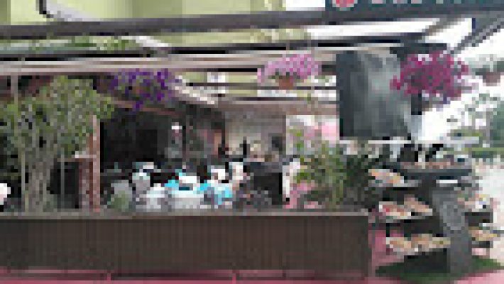 Sunny Restaurant, Cafe & Bar’da deniz manzarası eşliğinde lezzetli yemeklerin tadını çıkaran misafirler.