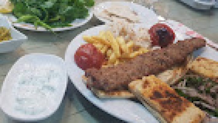 Mahmutlar Ocakbaşı’nda mangalda pişirilen etler, mezeler ve samimi ocakbaşı restoran ortamı.
