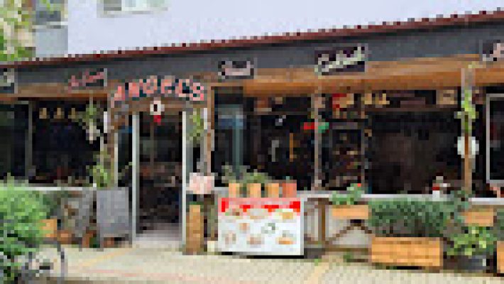 Angels Cafe Bar’da deniz manzarası eşliğinde keyifli vakit geçiren misafirler ve özenle hazırlanmış içecekler.