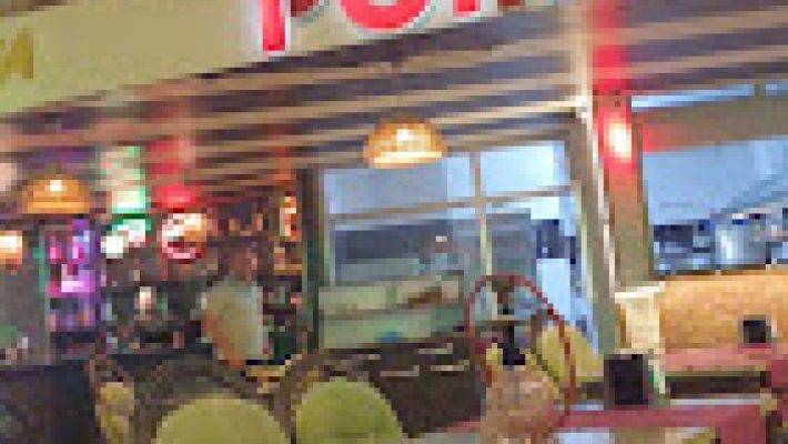 Nobody's Restaurant & Cafe Bar’da deniz manzaralı, sıcak dekorasyonlu ve ferah oturma alanına sahip şık bir masa düzeni.