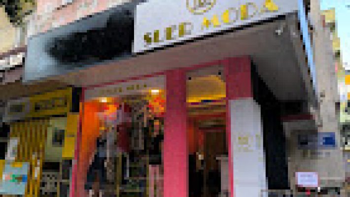 SUER MODA mağazasında sergilenen kadın ve erkek modern giyim ürünleri, elbiseler, ceketler ve kombin seçenekleri.