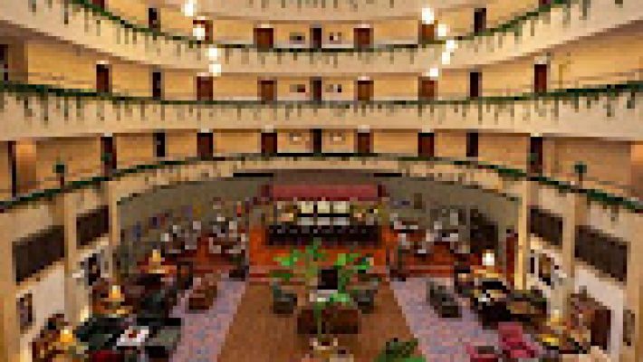 Royal Garden Select Suite Hotel’in denize sıfır konumdaki havuzu, lüks otel binası ve Akdeniz manzarasıyla birlikte güneşli bir yaz gününde görüntülenmiş