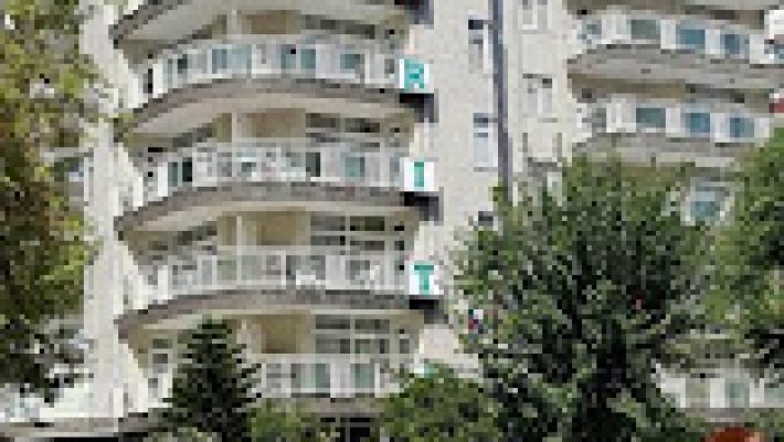 Carmen Suite Otel’in geniş açık yüzme havuzu, şezlonglarla çevrili dinlenme alanı ve modern otel binasıyla birlikte güneşli bir Alanya gününde çekilmiş görünümü