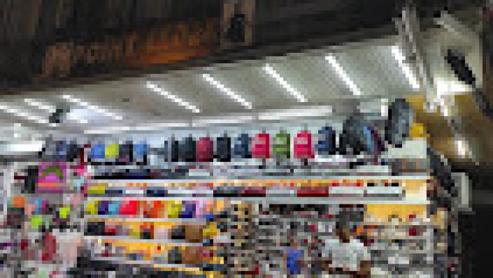 Point Leather mağazasında deri ceketler, çantalar ve aksesuarların şık bir şekilde sergilendiği iç mekan görüntüsü.